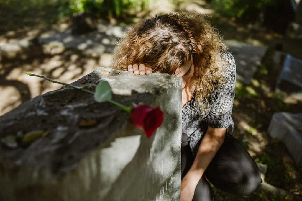 support through miscarriage-lady crying over grave
