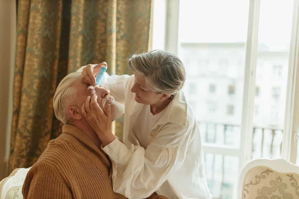 can dry eyes cause blurry vision: old women putting eye drops for old man